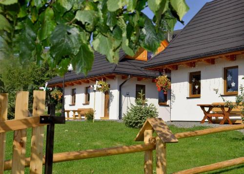a house with a wooden fence in front of it at Domki Górskie Zacisze in Koniaków