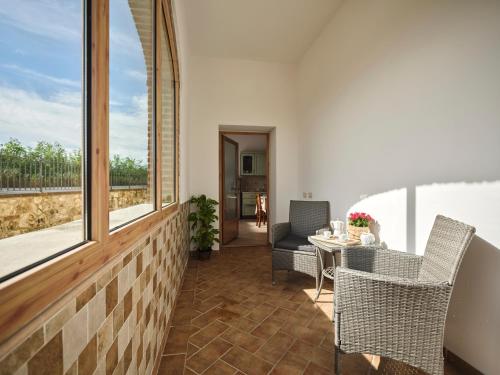 a patio with a table and chairs and windows at Casa Vacanze Santa Caterina in Asciano