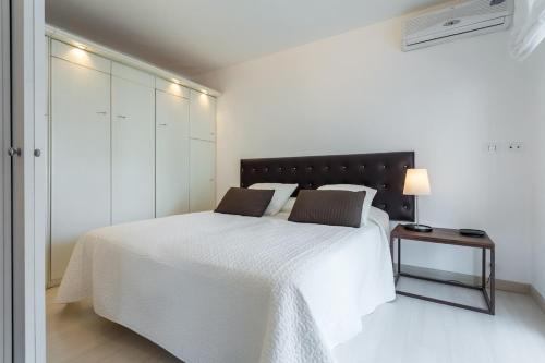 - une chambre blanche avec un grand lit blanc et une table dans l'établissement Charming & Elegant La Croisette apartment in Cannes, à Cannes