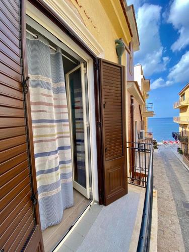a door to a balcony with a view of the ocean at Casa Vacanze Marco Polo vista mare in Trappeto
