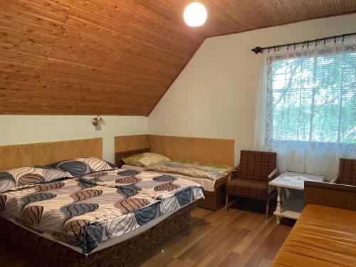 a bedroom with two beds and a window at Hutter Vendégház in Szántód