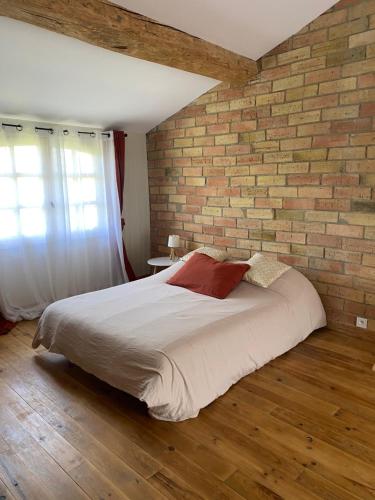 a bedroom with a brick wall and a bed at Maison de village in Fanjeaux