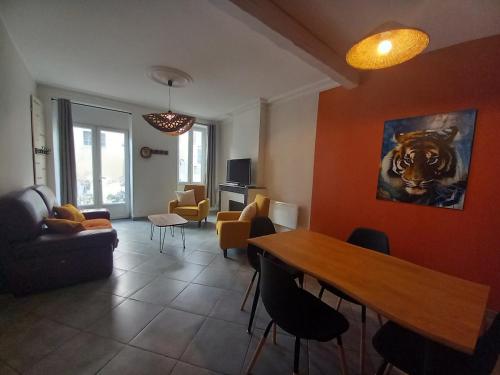 un salon avec une table et des chaises en bois dans l'établissement Maison de ville 3 chambres climatisées, à Bourg-Saint-Andéol