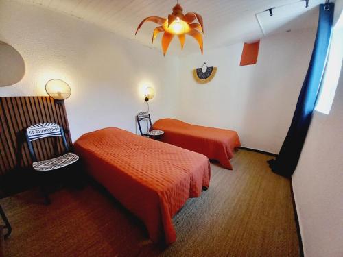 Cette chambre comprend deux lits et un lustre. dans l'établissement Maison de ville 3 chambres climatisées, à Bourg-Saint-Andéol