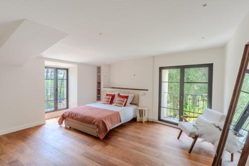 une chambre avec un lit et deux fenêtres dans l'établissement Villa Matacelle, à Mougins