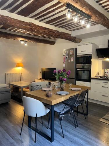une cuisine et une salle à manger avec une table et des chaises dans l'établissement La maison de village - Eyguières - Alpilles, à Eyguières