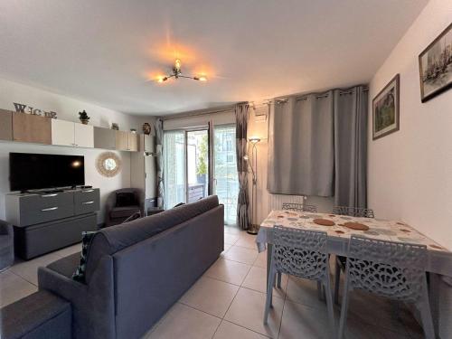 un salon avec une table et un canapé dans l'établissement Appartement 3 pièces avec jardin privatif - La Baule Centre - FR-1-245-102, à La Baule