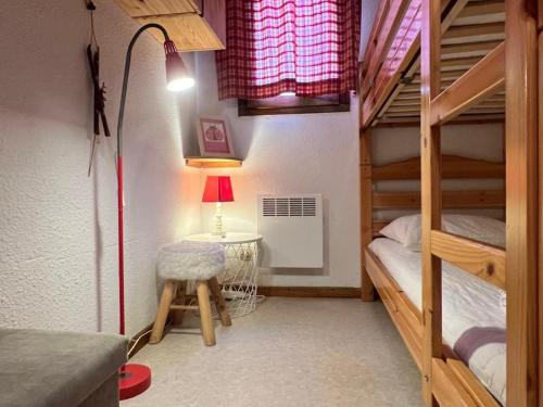 Cette chambre comprend deux lits superposés et une table avec une lampe. dans l'établissement Appartement 3 pièces avec parking et Wifi à Valloire - FR-1-263-60, à Valloire