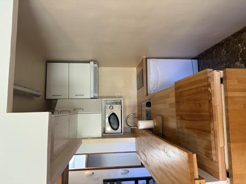 a small kitchen with white cabinets and a microwave at Canigou 56 by Confortsky in Pas de la Casa