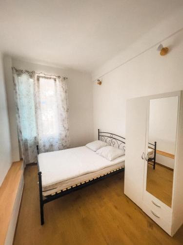 une chambre blanche avec un lit et un miroir dans l'établissement Typical Nice neighborhood 15 min from beach, à Nice