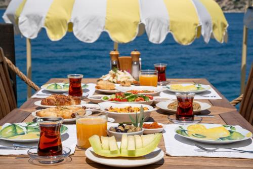 un tavolo con cibo e bevande su un tavolo vicino all'oceano di Loryma Luxury Hotel Bozburun a Bozburun