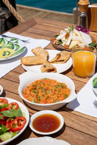 un tavolo in legno ricoperto di piatti di cibo e bevande di Loryma Luxury Hotel Bozburun a Bozburun