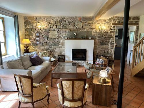 un salon avec un canapé et une cheminée dans l'établissement 210 - Maison de caractère pour 10 convives, à Plurien