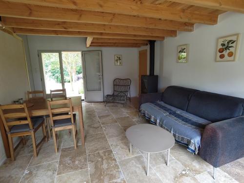 un salon avec un canapé et une table dans l'établissement La longère aux agrumes - gite piscine jardin-forêt, à Saint-Méard-de-Gurçon