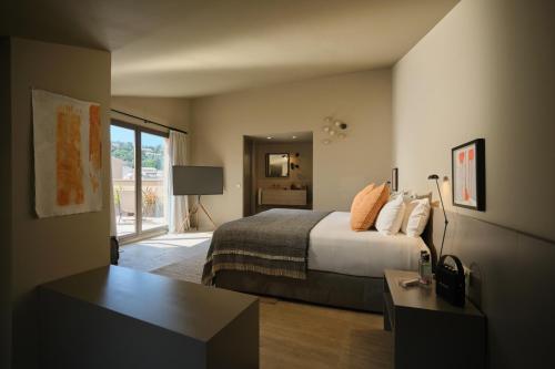 a bedroom with a bed and a desk and a window at Can Aulí Luxury Retreat - Adults Only in Pollença