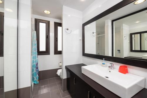 a bathroom with a white sink and a mirror at Villa Metis in Lachania