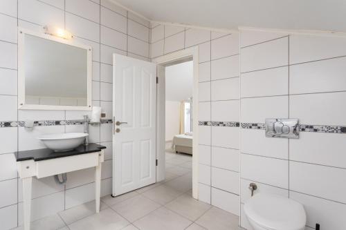 Un baño blanco con lavabo y espejo. en Golden Heights 5, en Ölüdeniz