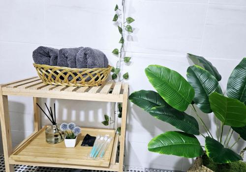ein Bambusregal mit Handtüchern und einer Pflanze in der Unterkunft Soul of Seoul - Cozy 3 room stay, 3min from SNU Station in Seoul