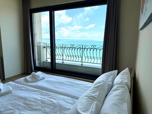 a bedroom with a large window with a view of the ocean at Cosher - Gardenia Palace Apt 10 Free Parking in Pomorie