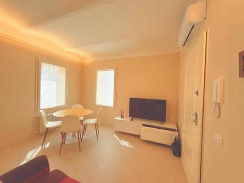 a living room with a table and a flat screen tv at Casa Edvige Suite in Monteveglio