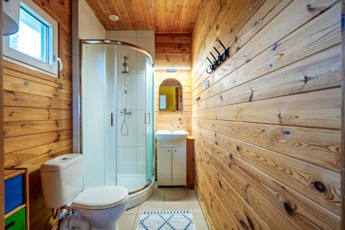 un bagno con wc e doccia e pareti in legno di Domki Irka nad morzem a Łeba
