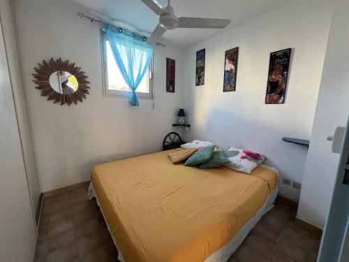 une chambre avec un lit et un miroir au mur dans l'établissement Appartement T2 avec Terrasse, Proche Plage, Le Barcarès - FR-1-81-589, au Barcarès