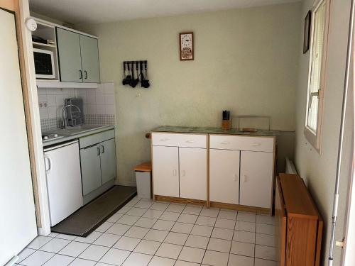 Il comprend une cuisine avec des placards blancs et du carrelage blanc. dans l'établissement Appart 2 pièces avec piscine et parking à Port Camargue - FR-1-250-293, au Grau-du-Roi