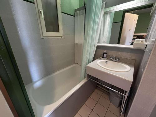 une salle de bain avec un lavabo, une baignoire et un miroir dans l'établissement Appart 2 pièces avec piscine et parking à Port Camargue - FR-1-250-293, au Grau-du-Roi