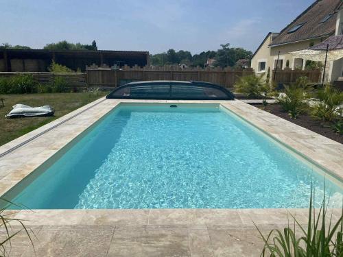 a swimming pool in a yard with a car in it at La Cabane Mini Enchantée ! in Thenay