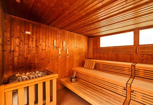 a wooden sauna with a bench and a window at Appartement Hella Wahnsinn in Sankt Englmar