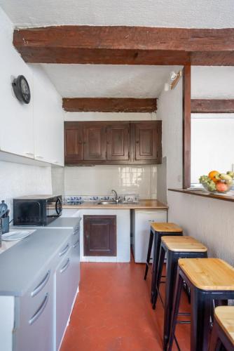 une cuisine avec des armoires en bois et une table et des chaises dans l'établissement La plaine Urban, à Marseille