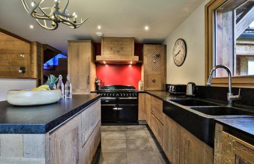 une cuisine avec un évier et une cuisinière dans l'établissement Chalet Arte 12px Hot Bath Sauna, aux Houches