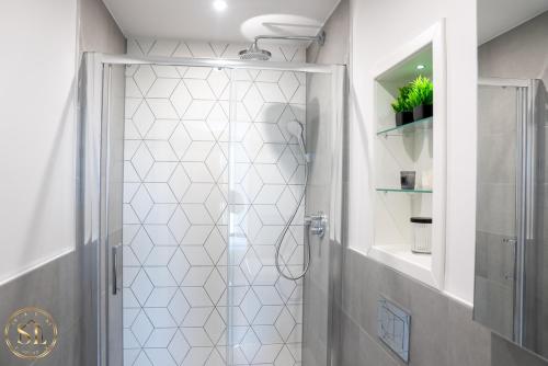 une douche avec une porte vitrée dans une salle de bain dans l'établissement Luxury 2 Bedroom 2 Bathroom Apartment In Wimbledon, à New Malden