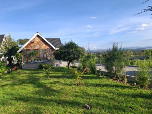 a house with a green yard with trees at The Cabin Azure in Naivasha