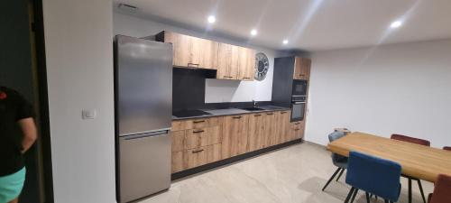 une cuisine avec des armoires en bois et un réfrigérateur en acier inoxydable dans l'établissement Maison de campagne, à Salon-de-Provence