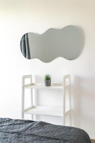 a bedroom with a mirror and a plant on a shelf at Varkizaki by the sea in Varkiza