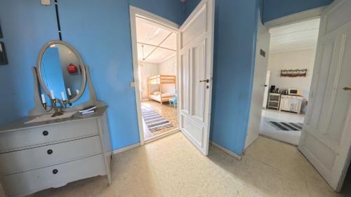 a bathroom with a mirror and a sink and a door at Medstugans Pilgrimsboende in Medstugan