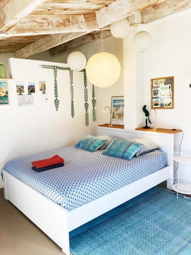 - une chambre avec un lit et une valise rouge dans l'établissement Les oliviers, à Saignon