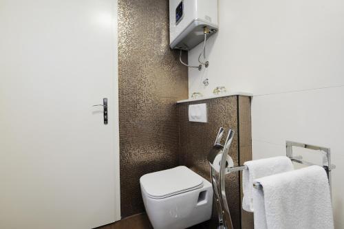 een kleine badkamer met een toilet en handdoeken bij Primera Luxury Studio in Zadar