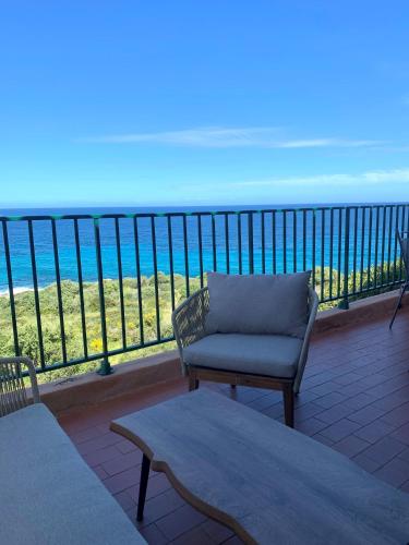 Elle dispose d'un balcon avec un canapé et une chaise. dans l'établissement Superbe appartement vue mer, à Monticello