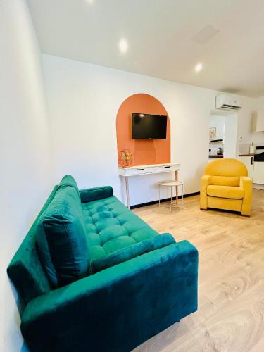 - un salon avec un canapé vert et un fauteuil jaune dans l'établissement Fontaine Bourguerins, à Menotey