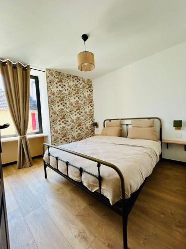 - une chambre avec un grand lit en face d'une fenêtre dans l'établissement Fontaine Bourguerins, à Menotey