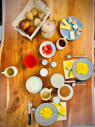 een houten tafel met daarop borden en kommen met eten bij HitTheRoad Fontaine Bourguerins in Menotey
