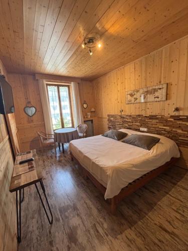 une chambre avec un grand lit et une table dans l'établissement Hôtel l'Hermitage, à Brides-les-Bains