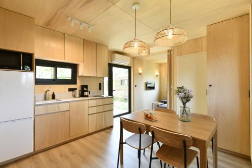 a kitchen with a table and chairs and a refrigerator at O Lodge les jardins d iode proche mer in La Brée-les-Bains