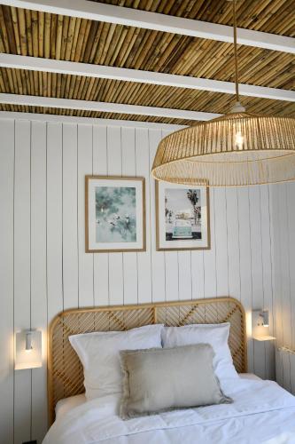 une chambre avec un lit avec un plafond en bois dans l'établissement O Lodge les jardins d iode proche mer, à La Brée-les-Bains