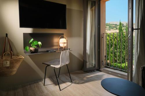 a room with a chair and a window with a view at Can Aulí Luxury Retreat - Adults Only in Pollença