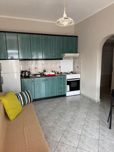 a kitchen with green cabinets and a white refrigerator at Villa Eleni in Ofrínion