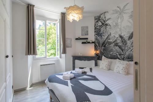 une chambre avec un lit avec une couette noire et blanche dans l'établissement C10 - 3P 10 min Palais Festivals & Sea - AC & Parking, à Cannes