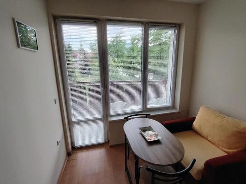 a living room with a table and a couch at Studio apartment with mountain view at Eagle Rock complex in Beli Iskar